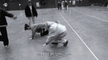 a group of people are playing on a concrete floor and one of them has the letter t on his shirt