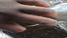 a close up of a person 's hand holding a piece of metal