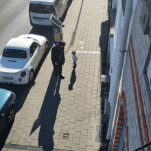 a man and a child are standing on a sidewalk next to a sign that says p.