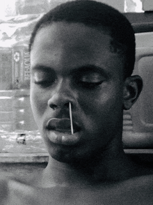 a black and white photo of a man with a toothpick sticking out of his mouth