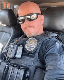 a police officer in a car wearing sunglasses and a badge that says california