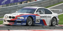 a bmw race car with the number 142 on it