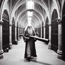 a black and white photo of a man with a beard holding a cannon in a hallway