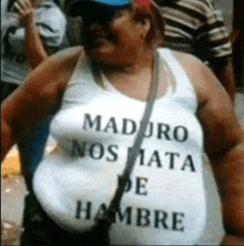 a woman is wearing a white tank top that says maduro nos mata de hambre