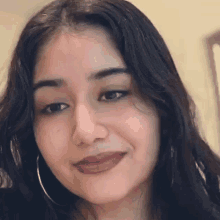 a close up of a woman 's face with hoop earrings on