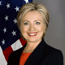 a woman in front of an american flag is smiling for the camera