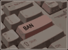 a person is pressing a pink button on a keyboard that says ban