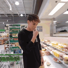 a man in a black shirt is standing in a grocery store with a sign on the wall that says " healthy choices "