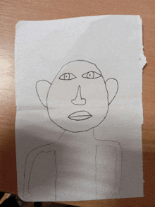 a child 's drawing of a man 's face on a piece of white paper