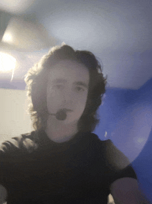 a young man wearing headphones and a microphone is taking a selfie