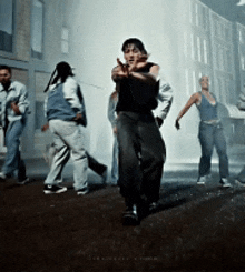 a group of people are dancing on the street and one of them is pointing