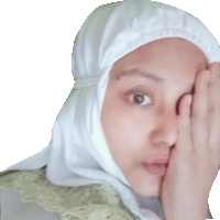 a woman wearing a hijab covering her face with her hands