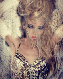 a woman wearing a leopard print top has her hair in a messy bun