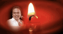 a man singing into a microphone with a candle behind him