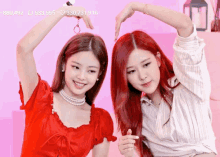 two girls with red hair are making a heart shape with their hands and the number 330731,916 on the bottom