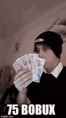 a man in a black beanie is holding a bunch of money with the words 75 bobux above him