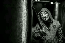 a man wearing an anonymous mask is holding a knife .