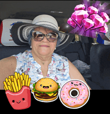 a woman wearing a hat and sunglasses is sitting in a car with a hamburger a donut and french fries