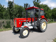 a red tractor with the word ursus on the front of it