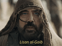 a man with a beard and a scarf around his head has lisan al-gaib written on the bottom