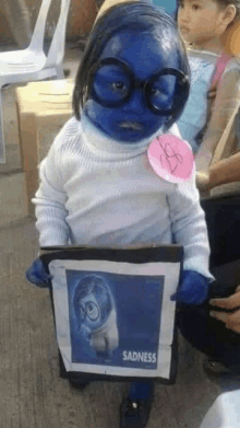 a little girl is dressed in a sadness costume .