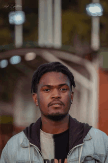 a man wearing a denim jacket with the word high written on the bottom