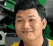 a close up of a man 's face with a yellow shirt on .