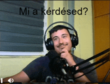 a man wearing headphones is sitting in front of a microphone with the caption " mi a kérdésed "