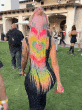 a woman with rainbow hair has a heart painted on her hair