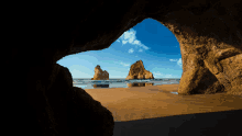 a view of a beach through a cave