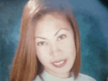 a close up of a woman 's face with long hair and a blue background .