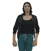 a woman in a black shirt and blue jeans is standing with her hands in front of her face