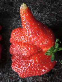 a strawberry shaped like a thumbs up sign