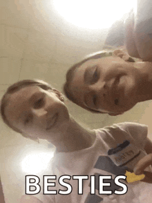 two young girls are taking a selfie and the words besties are on the bottom