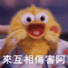 a person is holding a stuffed yellow duck with chinese writing on it .