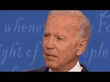 a close up of a man 's face in front of a blue background that says ' when ' on it