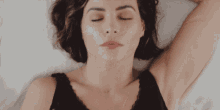 a woman laying down with her eyes closed