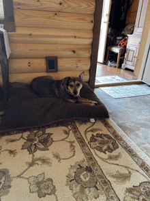 a dog is laying on a dog bed in a log cabin