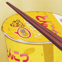 a cup of noodles with chopsticks on top of it