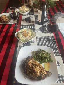 a bottle of wine sits on a table with plates of food