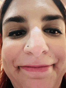 a closeup of a woman 's face with a nose ring