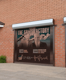 a brick building with a roller shutter that says the satisfaction