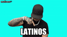 a man wearing a hat and a necklace with the word latinos written on it