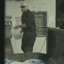 a man carrying a bag of ice stands in front of a sign that says no $ 500 for l