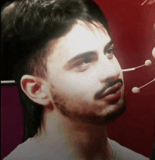 a close up of a man 's face with a needle sticking out of his nose