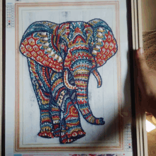 a person is holding a picture of a colorful elephant with numbers on it