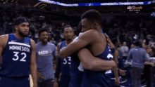 two minnesota basketball players hugging each other during a game