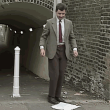 a man in a suit and tie is standing on a piece of paper in front of a brick wall