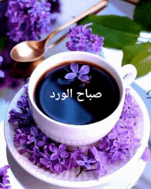 a cup of coffee surrounded by purple flowers with arabic writing