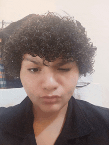 a woman with curly hair is making a face